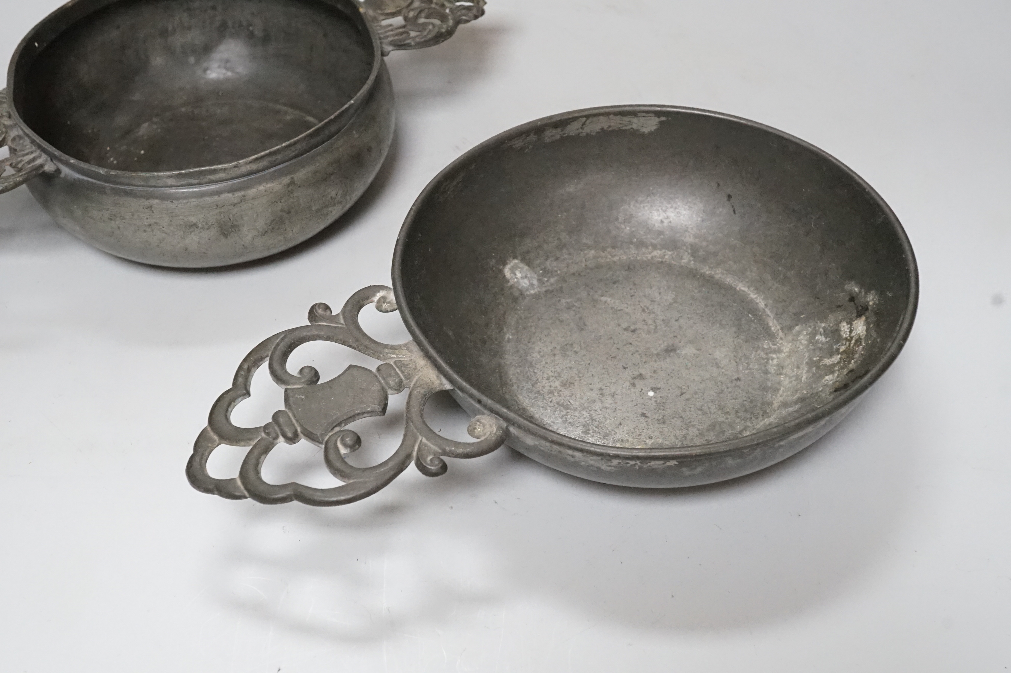 An 18th century French pewter two handled ecuelle, lacking cover, and one other, largest 27cm wide, (2)